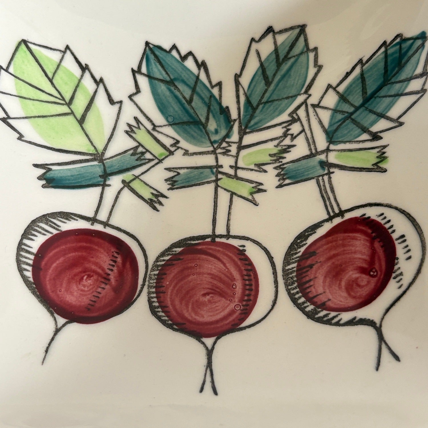 Hand-decorated root vegetable illustration inside Marianne Westman My Garden serving dish compartment